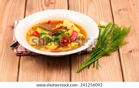 Hungarian hot soup on the wooden background.