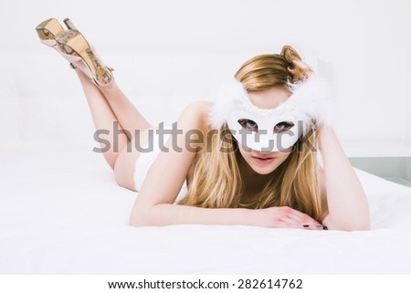 Sexy woman in white underwear and with mask on the bed