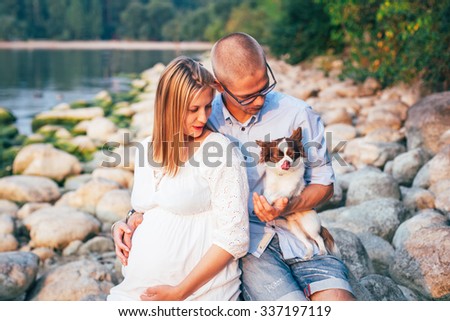 Pregnant woman. A family waiting for the child. Couple with a little dog