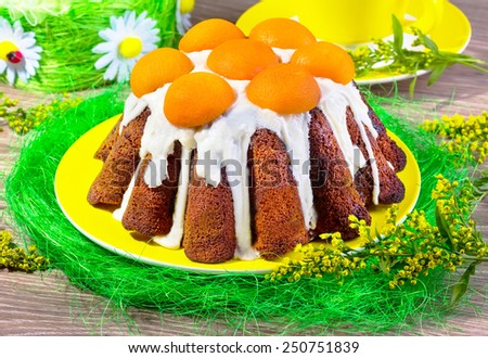 cake with glaze and apricots on a yellow plate with sisals and mimosas