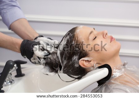 Beautiful woman washing hair in hair studio