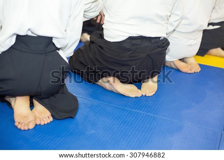 People in kimono and hakama sitting on tatami on martial arts training seminar. Selective focus