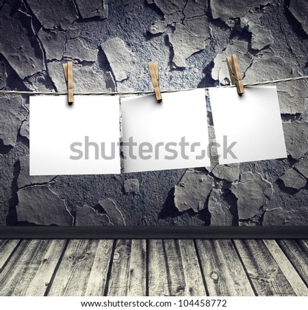 grunge interior, cracked wall wooden floor and white papers attach to rope with clothes pins