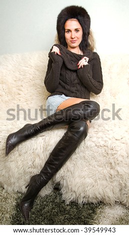 beautiful girl in black fur hat and leather boots