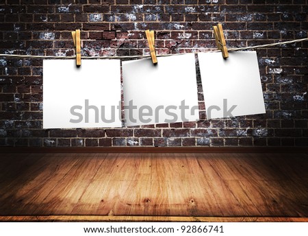 white papers attach to rope with clothes pins on brick wall background