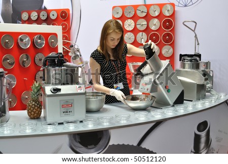 WARSAW - MARCH 26: The woman operating the machine to make salads - 14th International Food Service Trade Fair. March 26, 2010 in Warsaw, Poland.