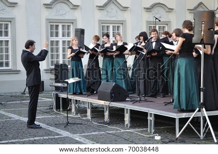 WARSAW - JUNE 28: Warsaw University of Technology Academic Choir sing during the concert in the court of the Royal Castle on June 28, 2009 in Warsaw, Poland. Dariusz Zimnicki conducts the choir.