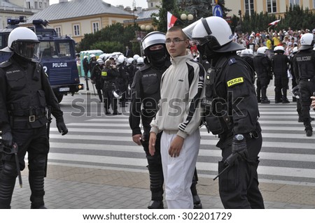 WARSAW, POLAND - JUNE 12, 2012 - Football fan is moved by riot police, protecting Russian fans marching to the stadium, during the Euro 2012 soccer championship, match between Poland and Russia.