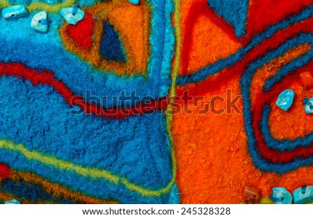 Multicolor abstract fabric texture of wool with stains and turquoise beads .; Craft background