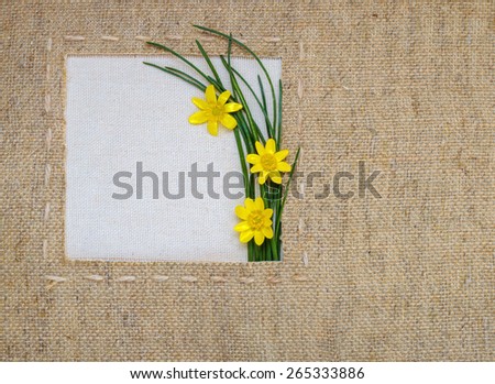 yellow flowers in the framework of burlap