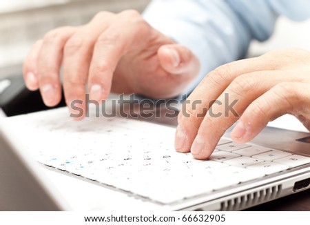 male hands writing on a white laptop