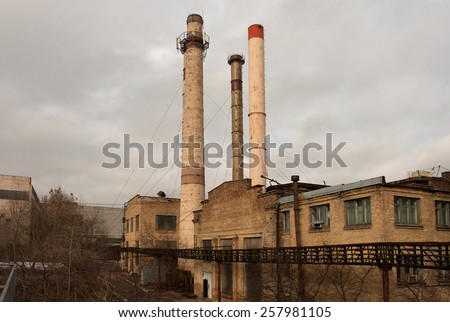old factory with three pipes on sky background