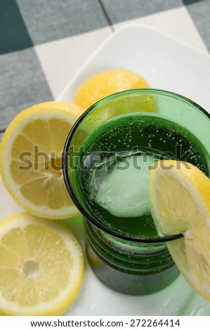 Carbonated Water with Lemons in a Green Glass