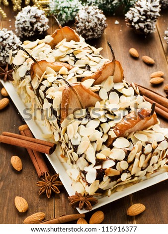 Christmas cake with pears, chocolate cream and almonds. Shallow dof.