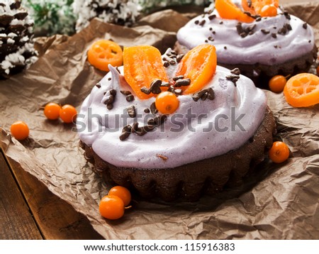Christmas dessert chocolate tarts with whipped cream and fruits. Shallow dof.
