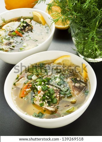 Bowls with soup with sturgeon and vegetables. Shallow dof.