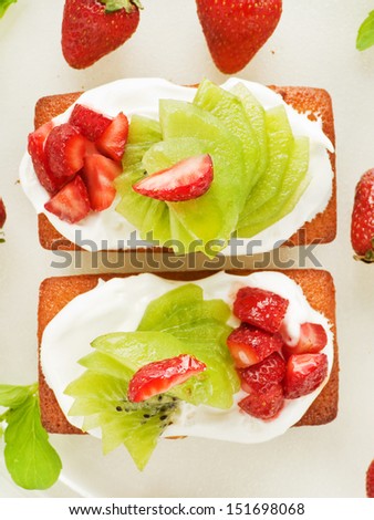 Coconut cakes with whipped cream, strawberry and kiwi. Viewed from above.