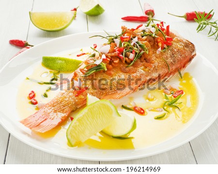 Steamed sea bass with chili pepper, rosemary, bacon and shallot onion in olive and linseed oil. Shallow dof.