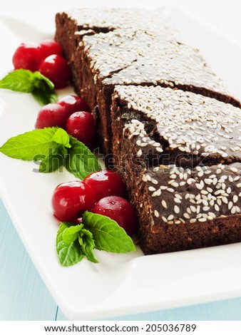 Brownies with chocolate chips, sesame seed and cherries. Shallow dof.