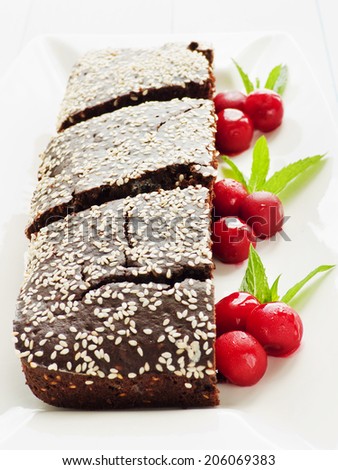 Brownies with chocolate chips, sesame seed and cherries. Shallow dof.