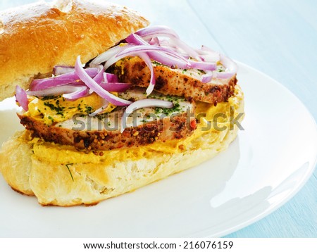 Plate with sandwich with baked turkey, sauce and veggies. Shallow dof.