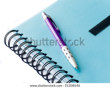 Spiral notebook with pen isolated over white background