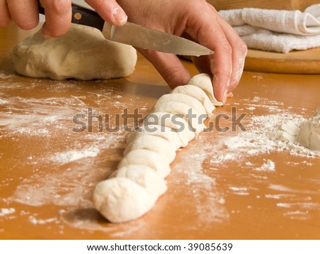 Female hands working with dough for varenyky (ukrainian national dish). Shallow DOF.