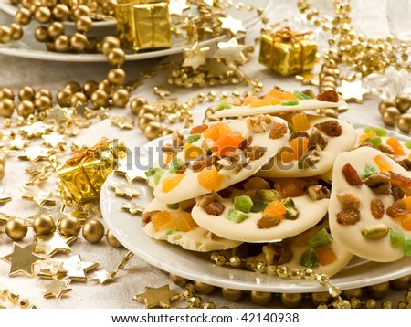Homemade white chocolate cookies decorated with dried apricots, pistachios, raisin, candied fruits and walnuts. Shallow dof.