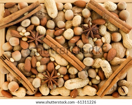 Wooden box with different kinds of nuts, cinnamon and anise. Viewed from above.