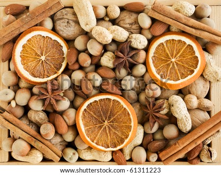 Wooden box with different kinds of nuts, spices and dried oranges. Viewed from above.