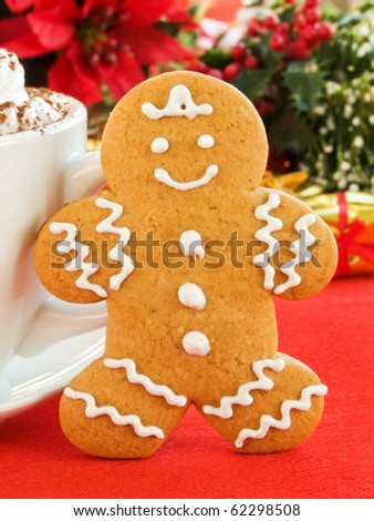 Homemade gingerbread man cookie and cup of chocolate with whipped cream. Shallow dof.