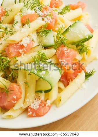Italian pasta penne with smoked salmon and cucumber. Shallow dof.