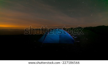 Camping in the Alps. Sunrise shot with stars in the sky.