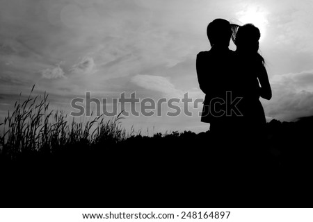 Man hugging woman silhouettes happy Couple in Love
