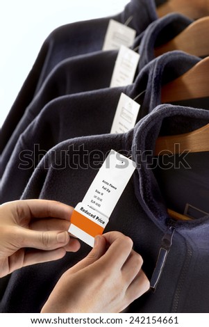 LABELING.  Clothing being labeled with a reduced price label in a store