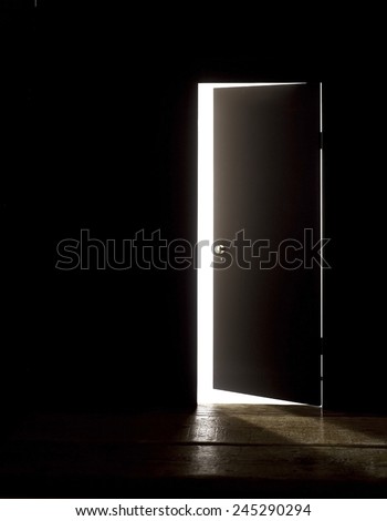 DARKENED ROOM DOOR OPEN WIDER - A door of a darkened room being opened