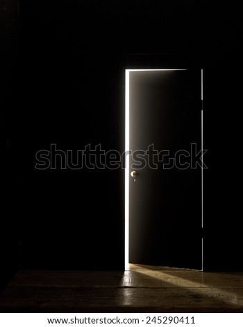 DARKENED ROOM DOOR SLIGHTLY OPEN - A door of a darkened room being opened