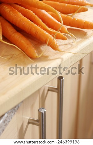 RAW CARROTS - A shot of recently dug fresh carrots on a kitchen worktop
