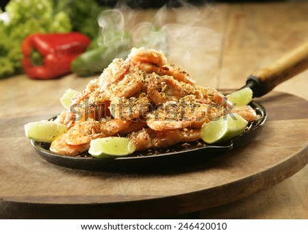 COOKED PRAWNS - A frying pan with steaming hot prawns