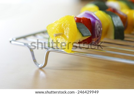 VEGETABLES ON A SKEWER - A close up of a vegetable kebab on a rack on a kitchen worktop