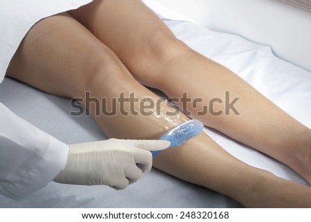 WAXING - A close up of a female\'s legs having hair removed by a professional