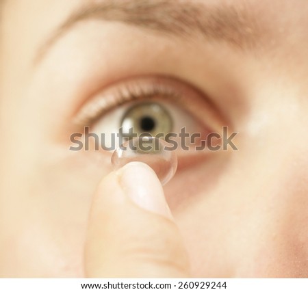 PUTTING IN A CONTACT LENS CLOSE UP - A close up straight on shot of a female putting in a contact lens into her eye