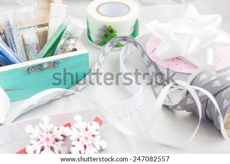 Gift packaging with colorful tapes, ribbons, shining sprinkles.