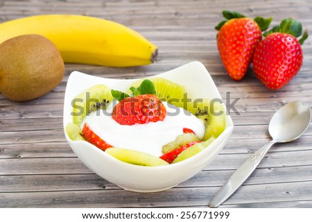 Fruit salad with kiwi, banana, strawberry and yogurt sauce. Juicy and full of vitamins.