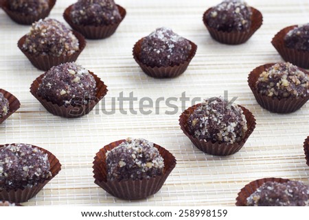 Raw snack balls with cocoa, jam and  walnut in small muffin papers.