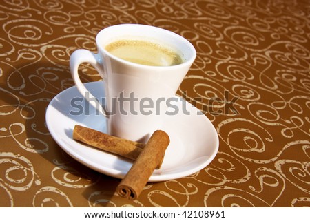 cup of coffee brown background with cinnamon stick