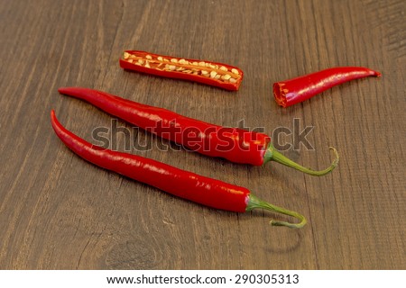 Red Chillies shown lying on a wooden background