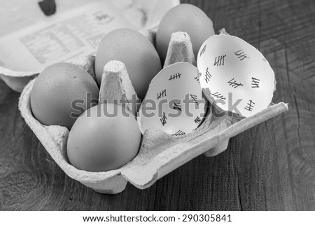 Egg shells shown lying on a wooden background with marks inside counting down the days till hatching,