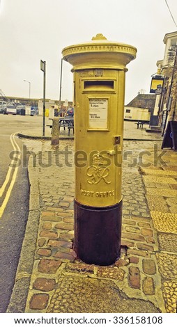 Penzance, Cornwall, UK, Jan 21 2014 -  Showing a gold postbox in reconition of Helen Glover winning an olympic medal in the 2012 London games, The first one to be painted gold in the UK,