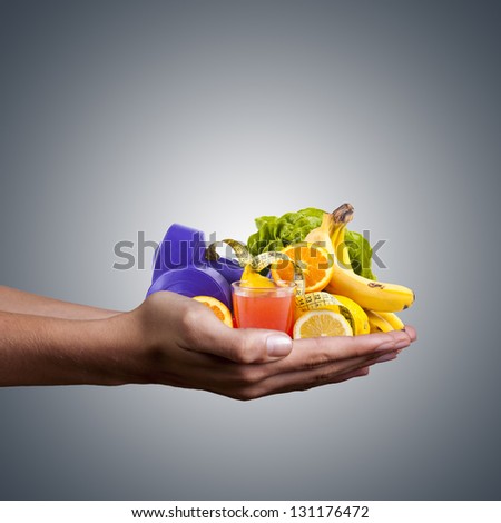 hands with healthy, natural foods, juice and weights for exercise